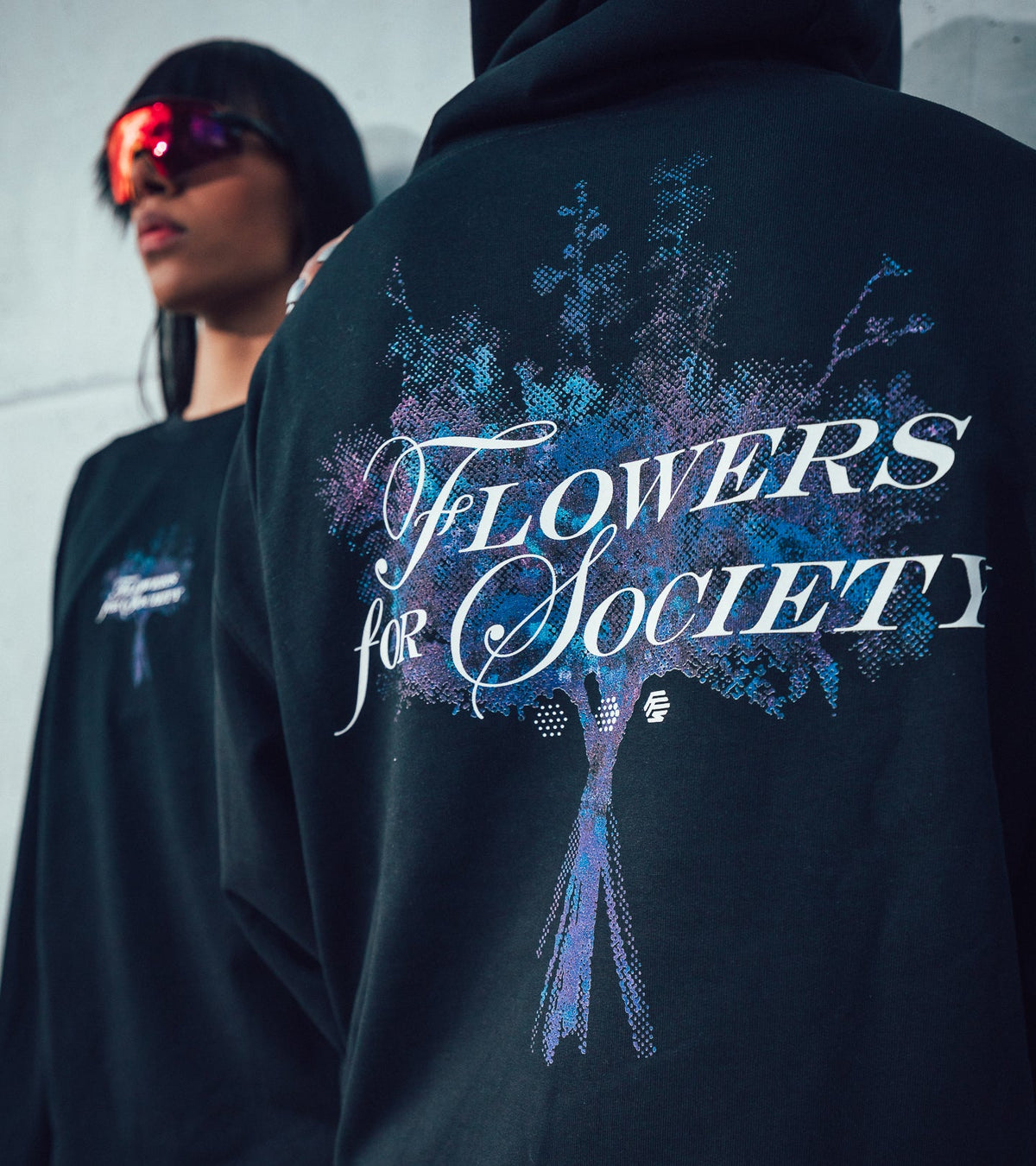 Two models posing, the left is seen from the front, the right one from the back. Both are presenting graphics from the Bouquet Collection on their clothing