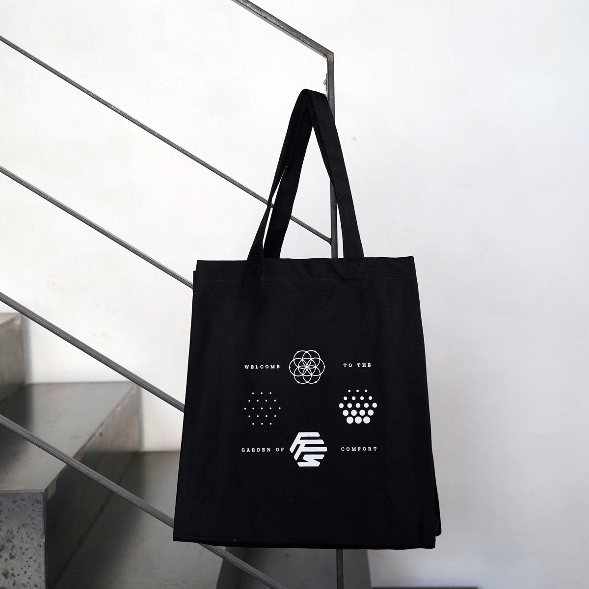 Flowers for Society OG logos jute bag black front view hanging on stair railing